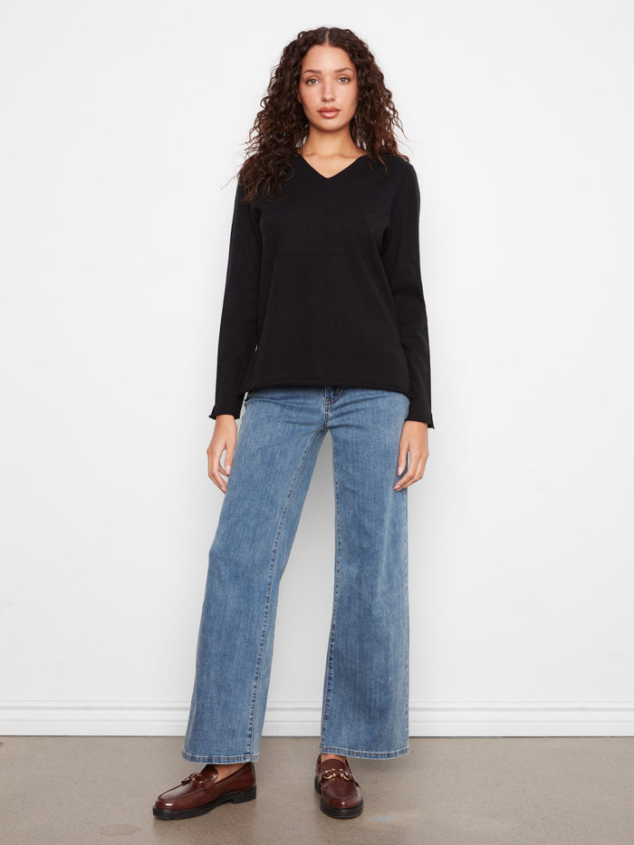 Black sweater crafted from soft knit fabric for warmth by Charlie B.
