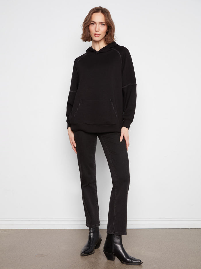 Unique blanket stitch details enhance the design, adding a subtle touch of elegance to the hoodie. By Charlie B.