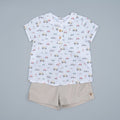 Children's shirt with car pattern and beige shorts on a gray background