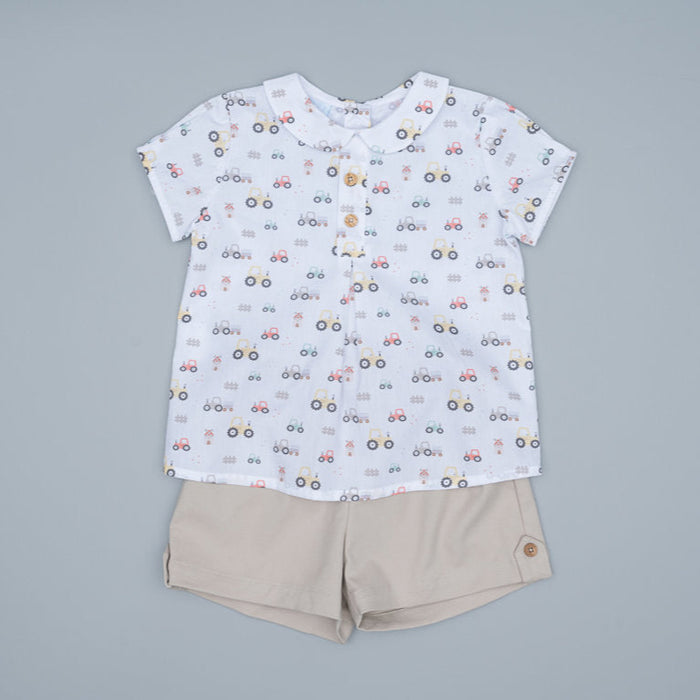 Children's shirt with car pattern and beige shorts on a gray background