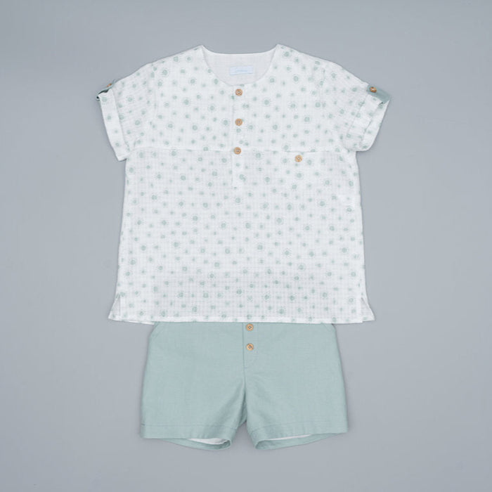 Children's outfit with a patterned shirt and light green shorts on a gray background