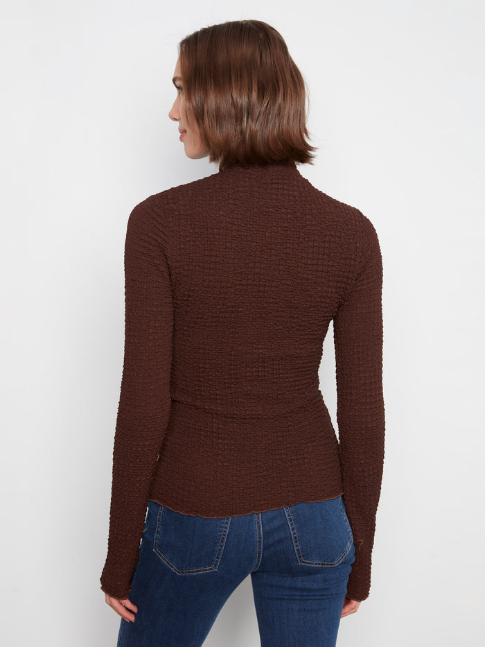 Featuring both style and comfort, the mock neck design complements the bubble knit texture seamlessly by Charlie B.