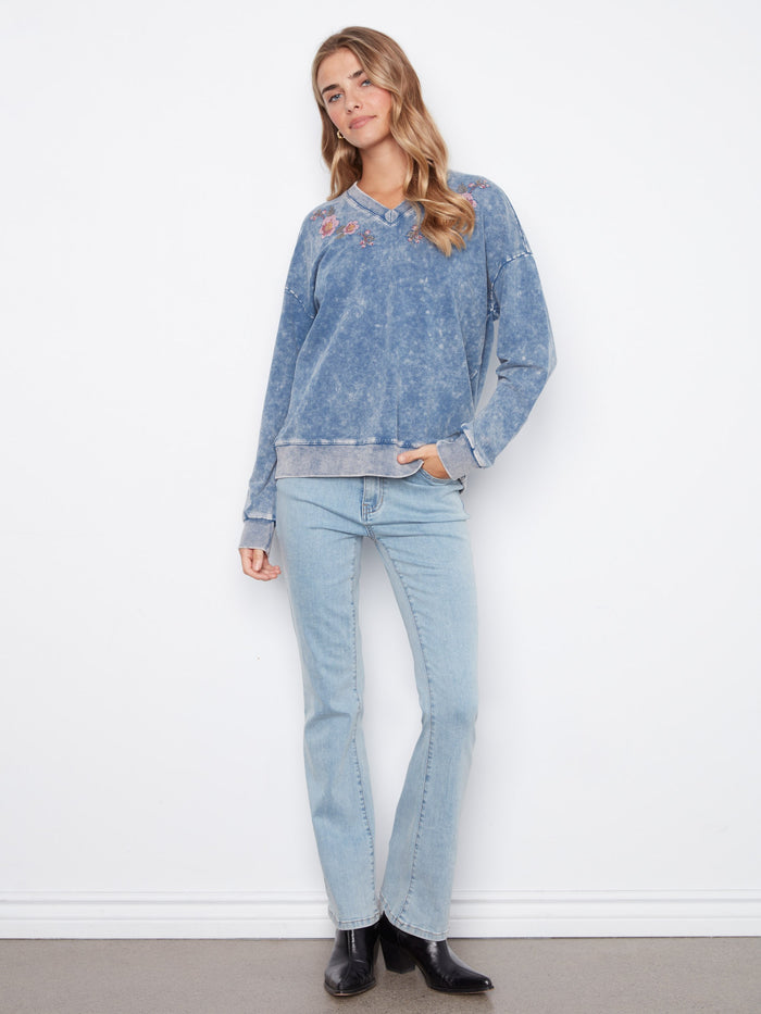 Stretch cotton denim blue top with V-neck and charming embroidered flowers for an elegant touch by Charlie B.