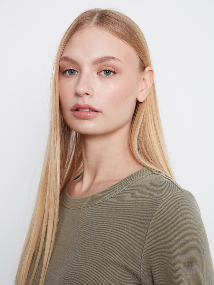 Close-up of an olive shirt crafted from a stretch cotton-tencel blend, ensuring flexibility and ease. By Charlie B.