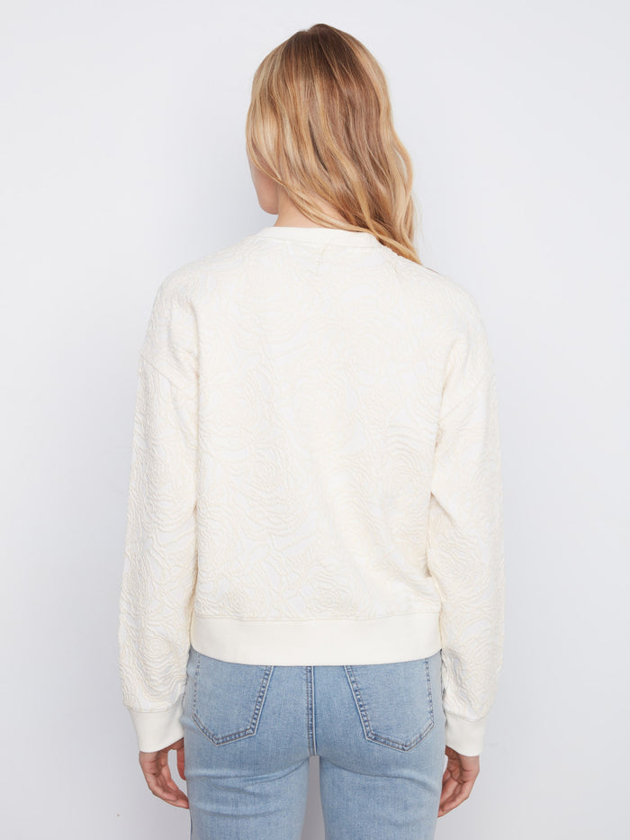Elegant buttercream sweatshirt showcasing ribbed cuffs and an all-over floral design for added texture by Charlie B.