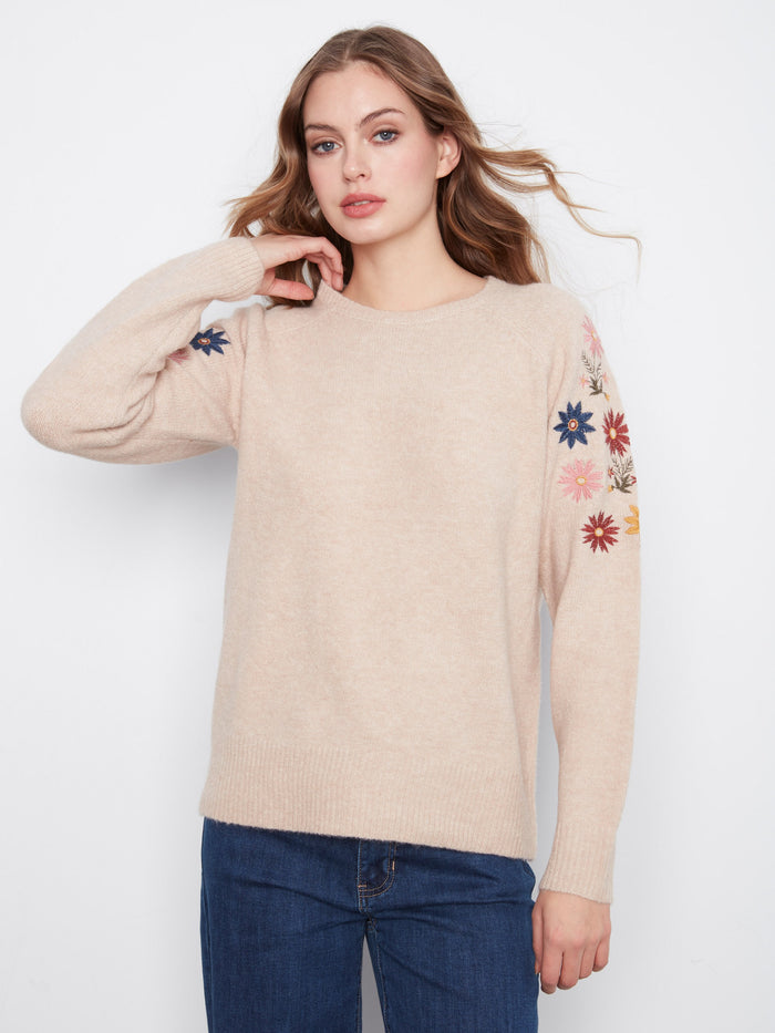 The raglan sleeves on this soft knit sweater offer comfort and style with floral detailing. By Charlie B.