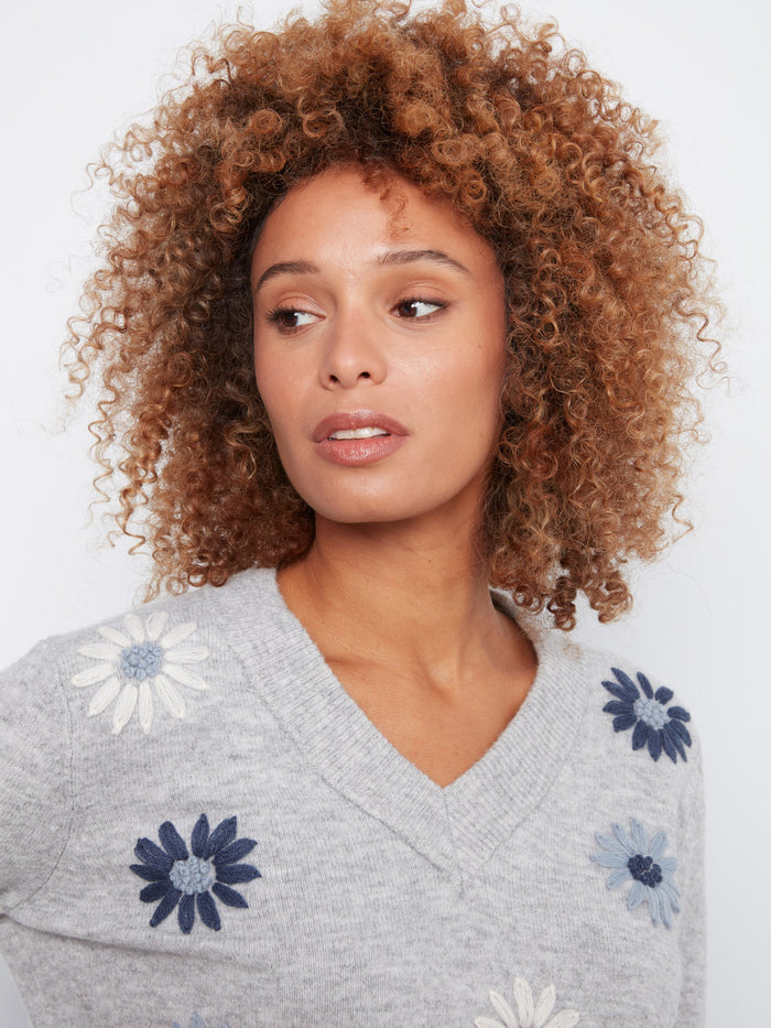 Stylish grey V-neck sweater adorned with intricate floral embroidery, ideal for layering by Charlie B.