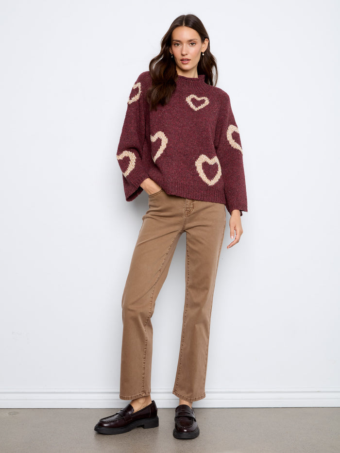 Stay comfortable and chic with this relaxed fit sweater, boasting delightful heart designs that add a playful touch to the look by Charlie B.