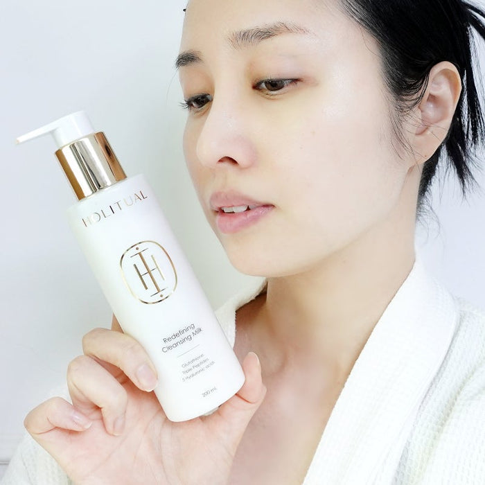 Woman holding HOLITUAL Redefining acleansing Milk 200ml