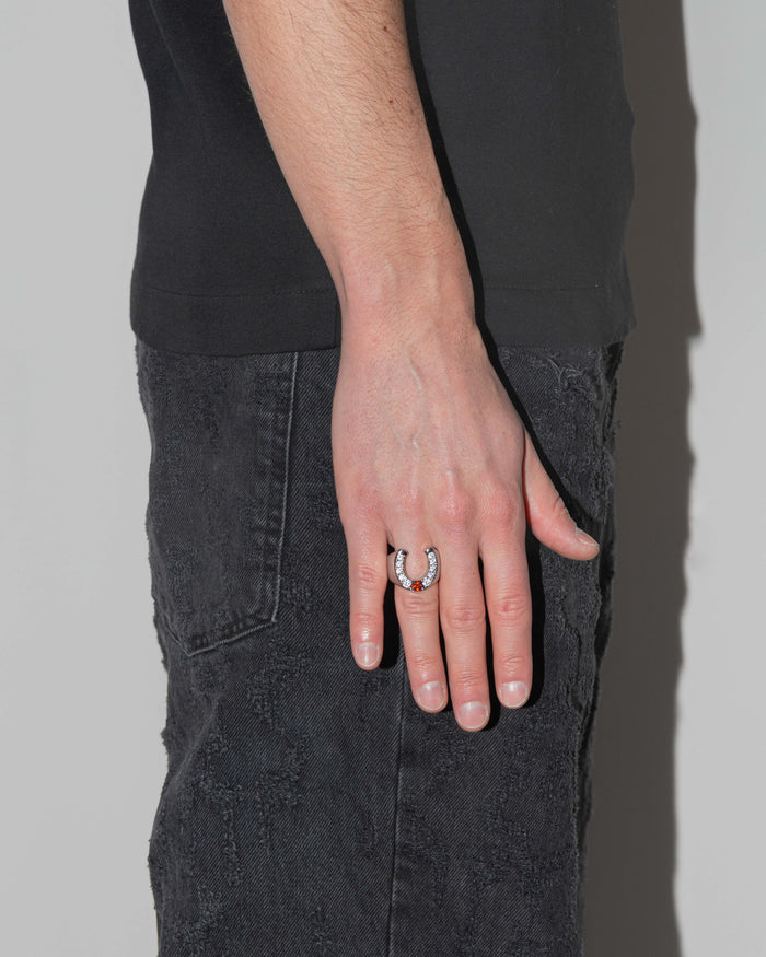 man wearing horseshoe ring with 18kt white gold coating and round shaped brilliant-cut diamond white stones with central princess-cut garnet stone