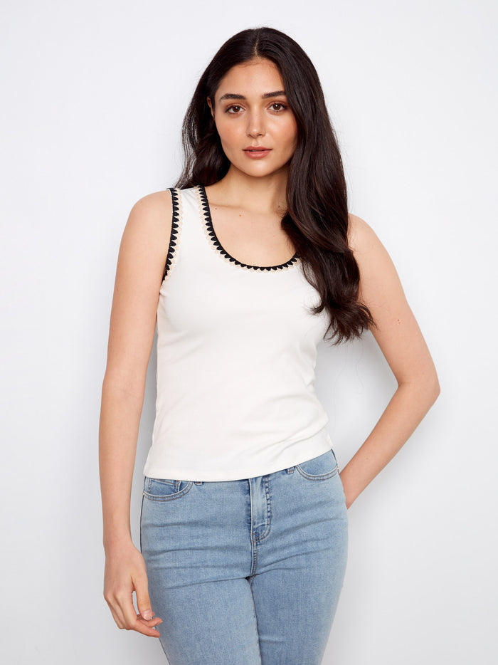 White tank top with a scoop neckline, featuring elegant sleeveless design and crochet accents for a stylish look by Charlie B.
