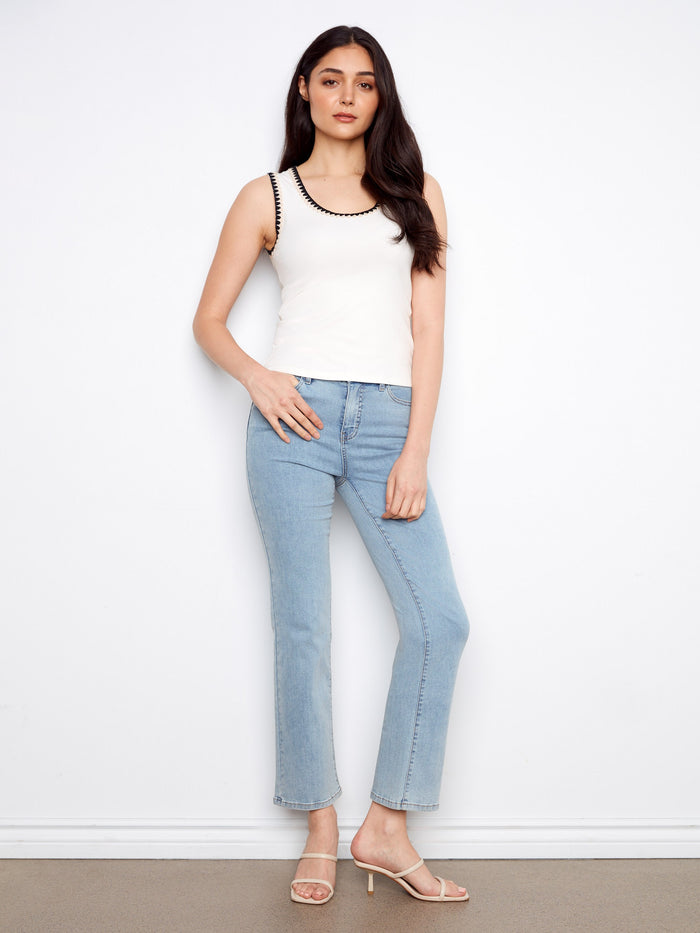 Chic white top with intricate crochet detail around the neckline, offering a modern sleeveless style by Charlie B.