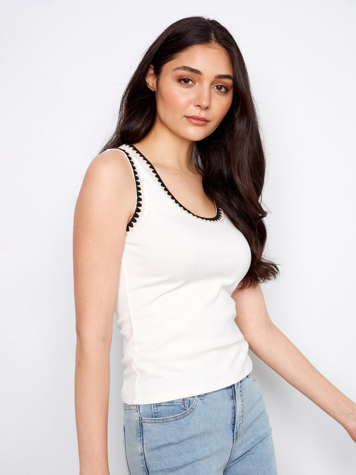 Elegant sleeveless white tank top highlighted by a scoop neckline and delicate crochet embellishments by Charlie B.