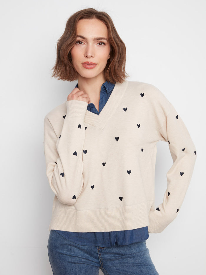 Sweater with a V-neckline and embroidered heart accents, paired with a layered shirt collar for a chic look by Charlie B.