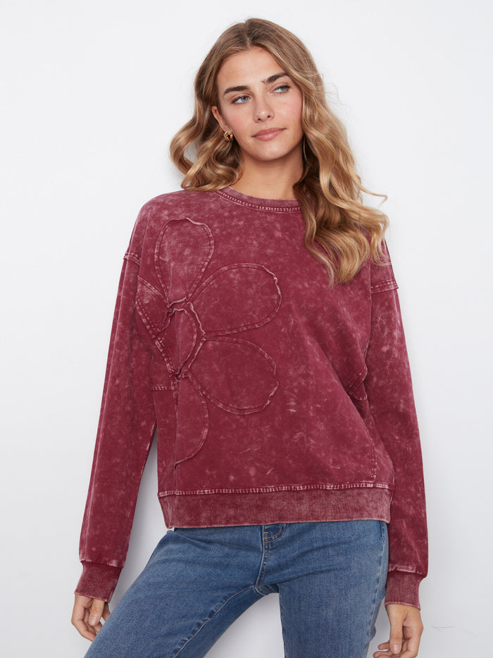 This garment features a floral appliqué detail, adding a touch of elegance to the stretch cotton fabric by Charlie B.