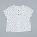 White t-shirt with subtle pattern on an ivory and mint background