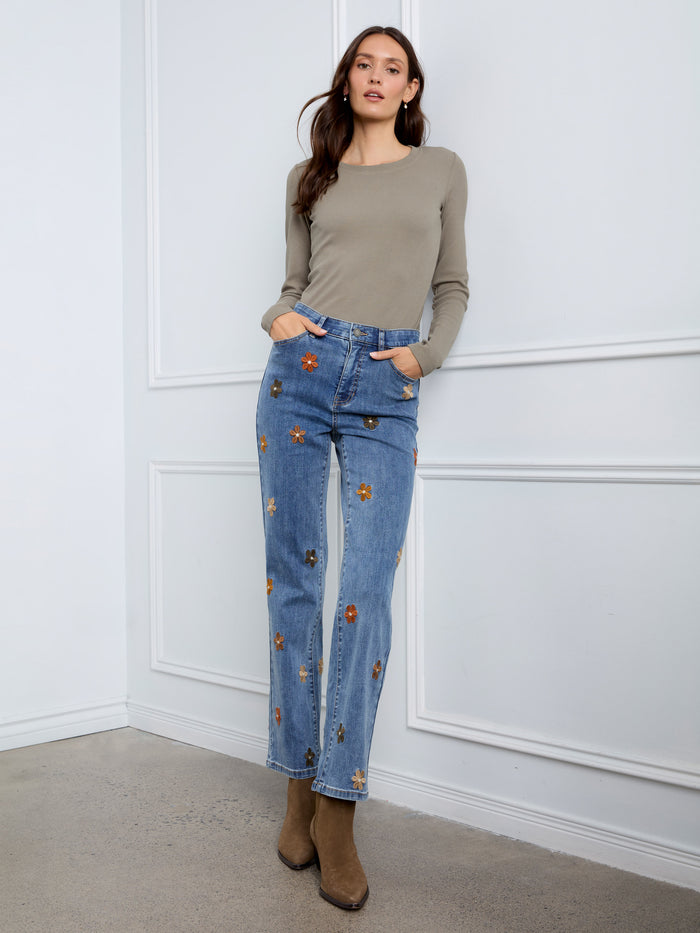These straight leg jeans are adorned with charming floral details that bring freshness to your ensemble. By Charlie B.